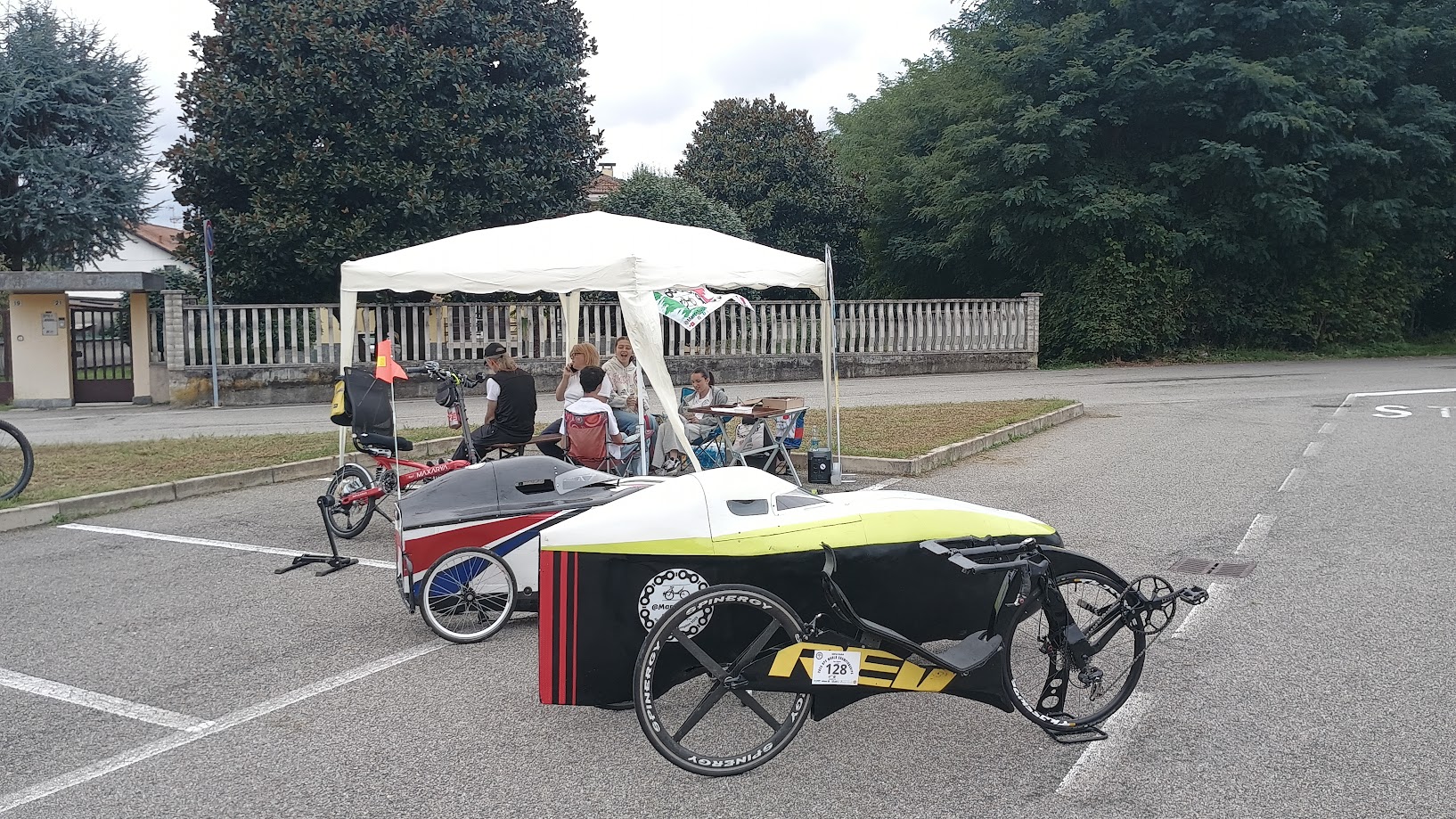 Biciclette reclinate e velomobili radunati davanti allo stand dell’ASD Velocità a Pedali