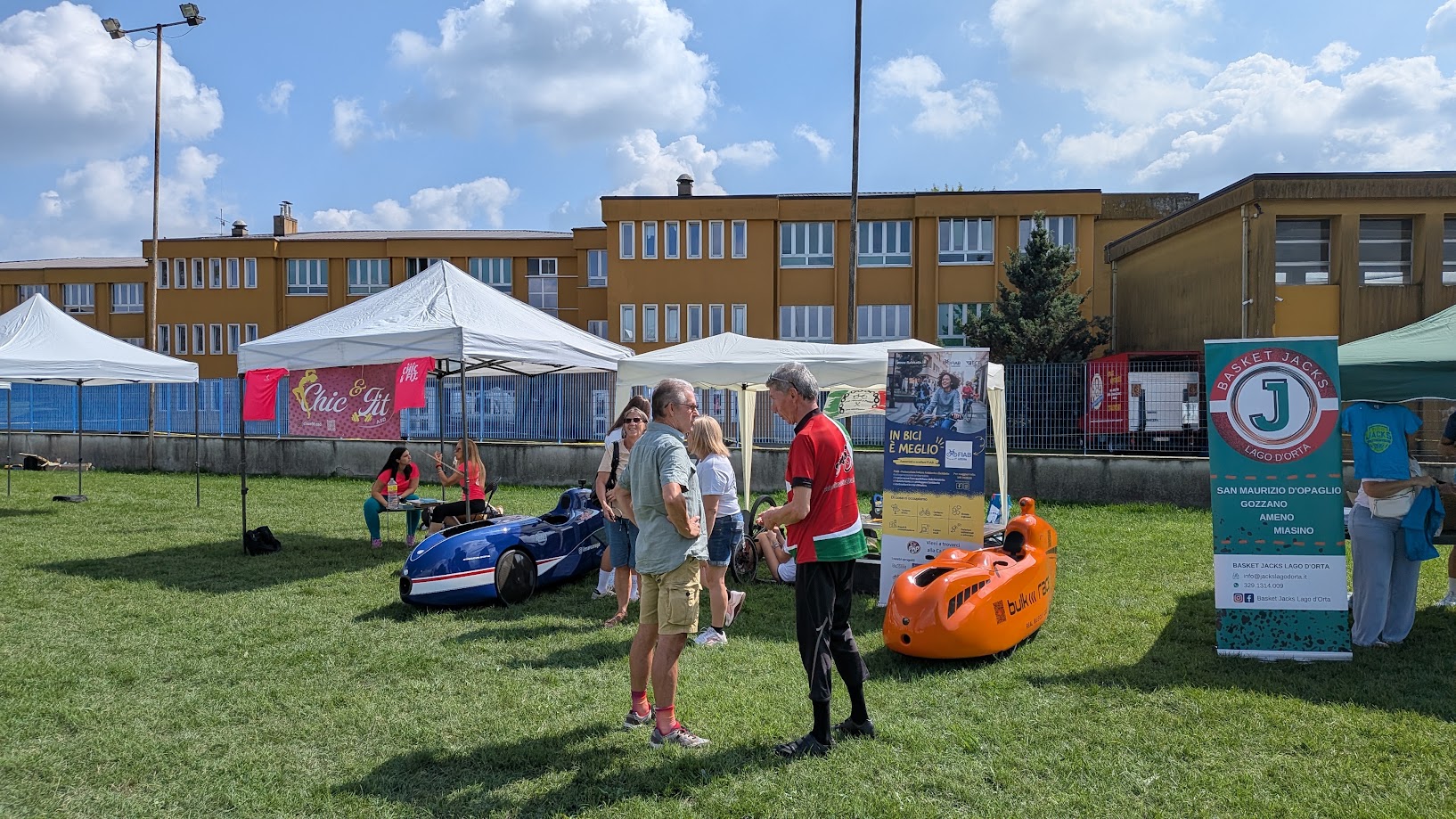Visitatori parlano con i soci accanto ai velomobili esposti allo stand HPV